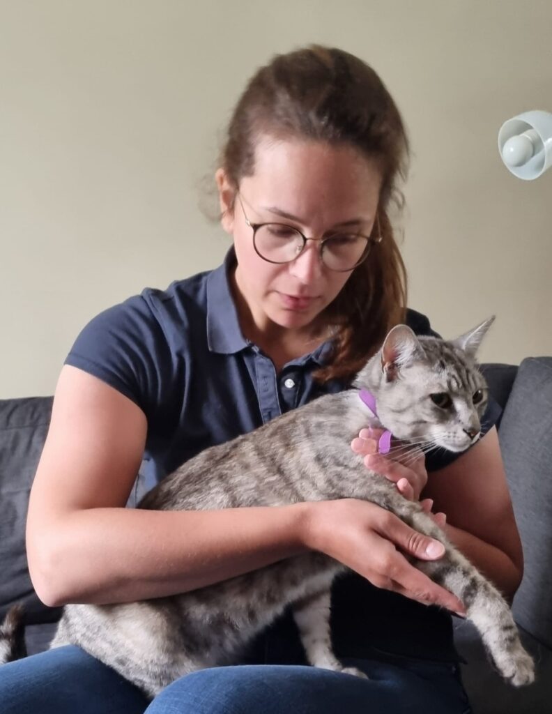 Audrey Teixeira, enseignante permanente, tenant sur ses genoux un chat tigré gris, les mains posées sur lui